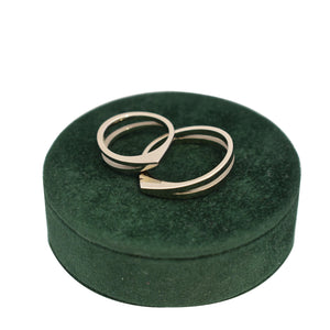 Dynamische geometrische witgouden V-ring trouwringen op groen doosje